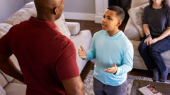 Durante a adoração em família, um menino treina com seu pai como dar uma resposta para alguém que faz uma pergunta.