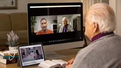 Un anciano le hace una visita de pastoreo a un hermano por videoconferencia. El anciano tiene la Biblia abierta, y en su tableta se ve el video “Cómo tener una familia feliz”.