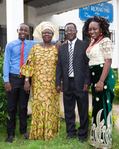 Israel and Dorcas with their son, Eric, and daughter, Jahgift, in front of the Kingdom Hall.
