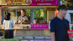 A man in a food truck serving a meal to a customer.