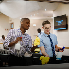 Two brothers cleaning a window at the Kingdom Hall.