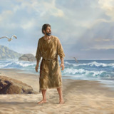 Der Prophet Jona steht am Strand und schaut zum Himmel. Er ist ganz nass und das Wasser tropft von ihm herunter.