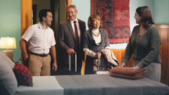 A couple in their home showing a traveling overseer and his wife their guest room.