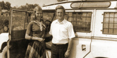 Mats and Ann-Catrin standing next to their SUV in a rural territory.