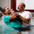A man being baptized in a pool.