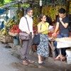 Two of Jehovah’s Witnesses preach in a marketplace in Indonesia