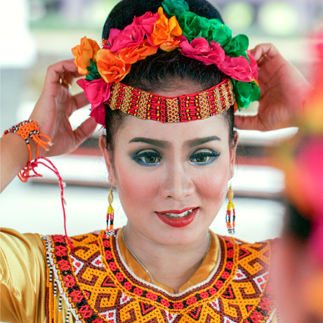 An Indonesian woman puts on a native headdress