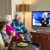 Un couple âgé et un jeune garçon regardent une émission de JW Télédiffusion