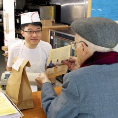 One of Jehovah’s Witnesses offering a Bible tract to a Chinese man