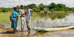 Testemunhas de Jeová pregando as boas novas a um pescador às margens do rio Okavango, em Botsuana