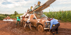 Men work together to dig a truck out of the mud