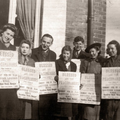 Ronald Parkin e outros irmãos com placas convidando pessoas para um congresso na Irlanda