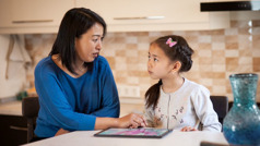 A mother talks with her daughter about watching harmful entertainment on her electronic device