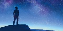 Um homem olhando para o céu estrelado.