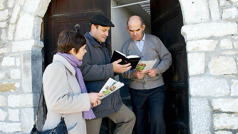 Miriam and Eliseo preaching to a man at his doorstep.