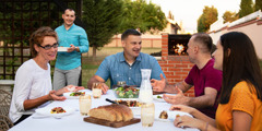 Irmãos e irmãs desfrutam de uma refeição tradicional albanesa ao ar livre.