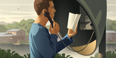 A young man using a public phone to study the Bible.