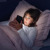 Ein Mädchen benutzt im Bett ihr Smartphone.