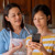 Egy tizenéves lány mutat valamit az anyukájának az okostelefonján.