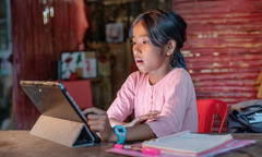 Mientras hace las tareas de la escuela, una niña se queda en shock al ver algo en la pantalla de su tablet.