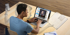 Seorang remaja sedang multitasking. Dia sedang video call dengan temannya, belajar, dan menggunakan HP untuk mencari informasi di Internet.