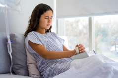 Ista najstnica moli na postelji v bolnišnici.