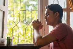 A teenage boy praying.