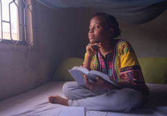Seorang remaja perempuan sedang merenungkan apa yang dia baca dari Alkitab.