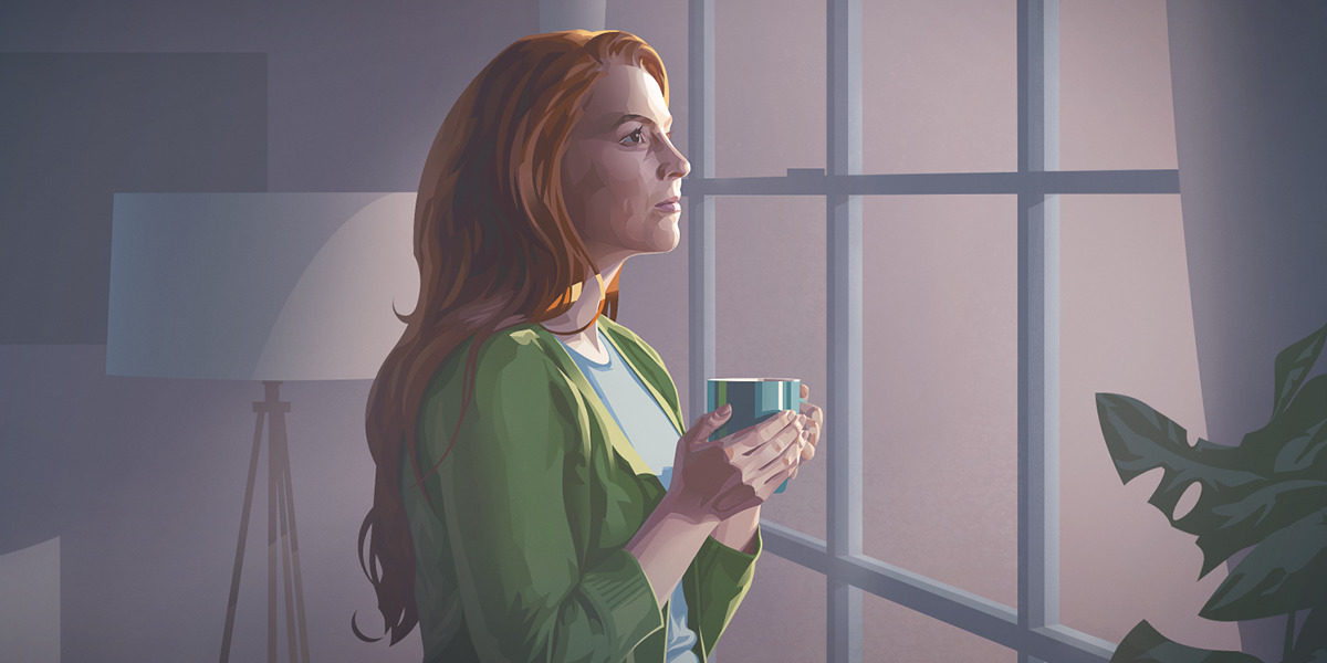 Una mujer en casa mirando pensativa por la ventana.
