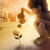 O fetiță udă o floare. În fundal se văd clădiri industriale care poluează mediul