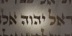 Uma página da Bíblia. O nome de Deus em hebraico está destacado.