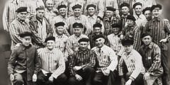 Gruppo di uomini rinchiusi in un campo di concentramento.