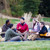 En un jardín, un grupo de jóvenes adultos hablando y pasando un buen rato.
