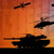 Silhouettes of military aircraft and vehicles against a backdrop of currency from around the world.