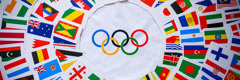 The Olympic symbol surrounded by the flags of many nations.