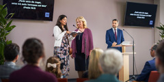 Two of Jehovah’s Witnesses at the midweek meeting, giving a demonstration from the Kingdom Hall platform.