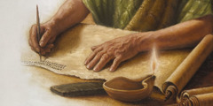 A man’s hands writing in a scroll