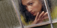 A lonely young woman looking out a window