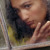 En ensom ung kvinne ser ut av et vindu