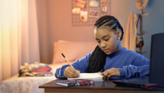 A teenage girl writing a letter.