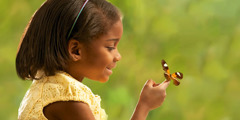 Uma menina olhando para uma borboleta; dois seres vivos, ou almas.