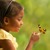 Uma menina olhando para uma borboleta; dois seres vivos, ou almas.