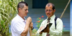 Một Nhân Chứng Giê-hô-va đang chia sẻ niềm tin từ Kinh Thánh với người hàng xóm