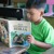 A young boy reading My Book of Bible Stories in Pangasinan