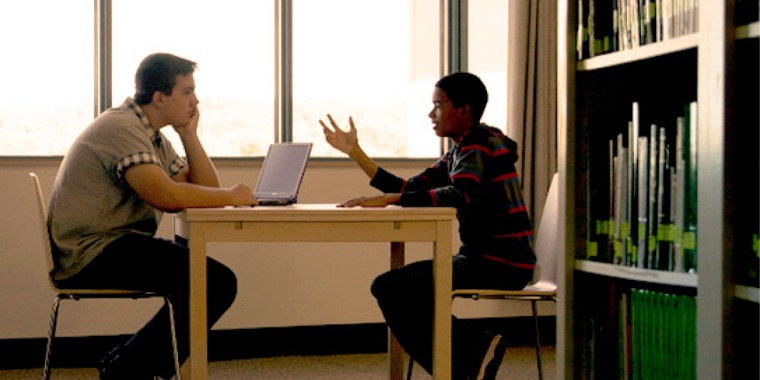 A young man explaining why he believes in God to a fellow student