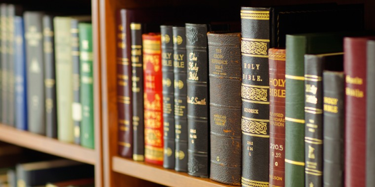 Various Bible translations on a bookshelf