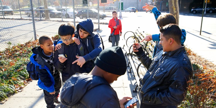 A boy being invited by other boys to view pornography on a cell phone