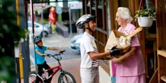 Um adolescente ajuda uma mulher idosa com as compras