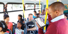 Un home usa JW Library al seu mòbil mentre viatja en transport públic