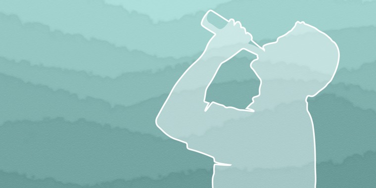 A silhouette of a man with his head tipped back as he drinks from a bottle
